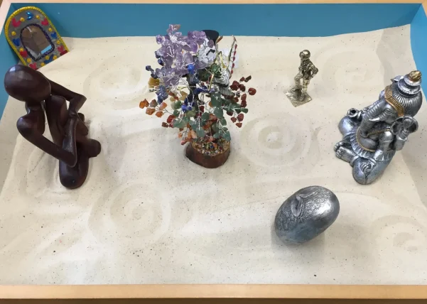 Sand tray with miniature figures used in therapeutic work.